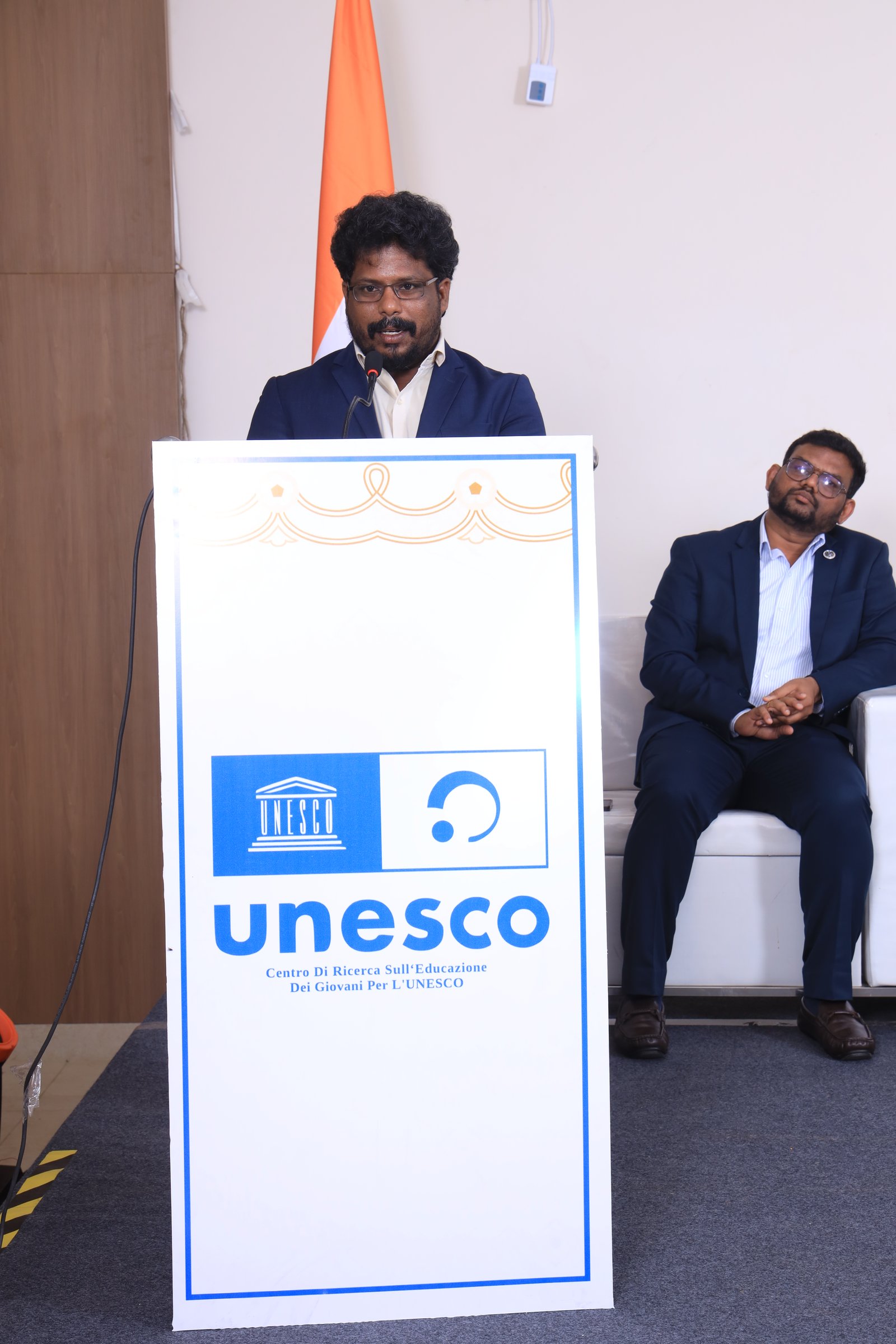 Close view of Dr. Datchanamoorthy Ramu speaking at the podium